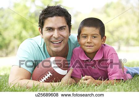 Father And Son In Park With American Football View Large Photo Image Stock Photo - Father And Son In Park With American Football. Fotosearch