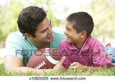 Stock Photograph - Father And Son In Park With American Football. Fotosearch