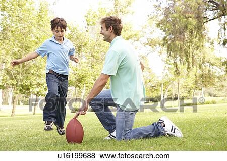 Stock Photo - Father And Son Playing American Football Together. Fotosearch