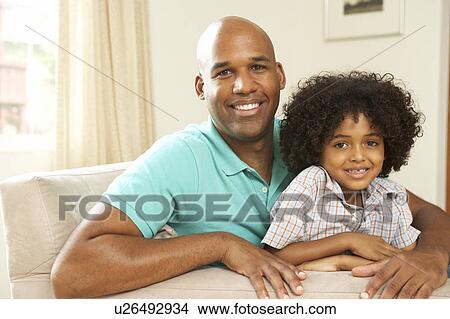 Father And Son Relaxing On Sofa At Home View Large Photo Image Picture - Father And Son Relaxing On Sofa At Home. Fotosearch