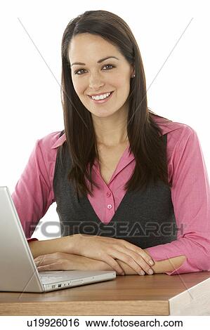 Stock Photograph - Female Businesswoman Using Laptop At Desk. Fotosearch