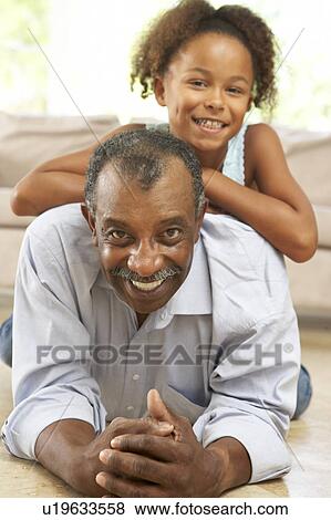 Grandfather And Granddaughter Playing Together At Home View Large Photo Image Stock Photo - Grandfather And Granddaughter Playing Together At Home. Fotosearch