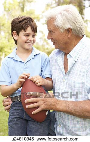 Stock Photography - Grandfather And Grandson Playing American Football Together. Fotosearch