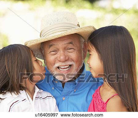 Stock Photo - Grandfather With Granddaughters In Garden. Fotosearch