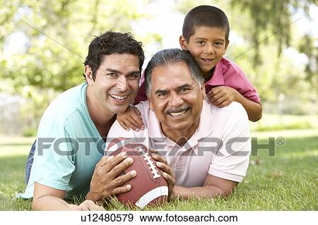 Stock Photo - Grandfather With Son And Grandson In Park With American Football. Fotosearch