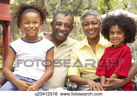 Grandparents Relaxing In Garden With Grandchildren View Large Photo Image Stock Photograph - Grandparents Relaxing In Garden With Grandchildren. Fotosearch