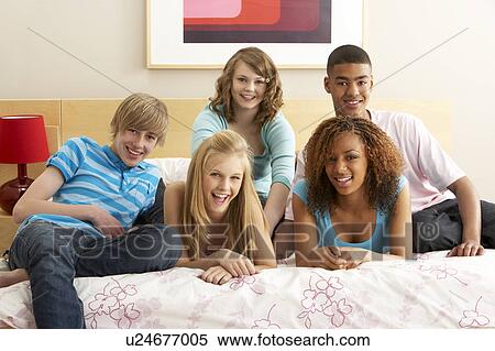 Stock Photography - Group Of Five Teenage Friends Hanging Out In Bedroom. Fotosearch
