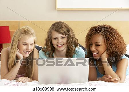 Stock Photo - Group Of Three Teenage Girls Using Laptop In Bedroom. Fotosearch