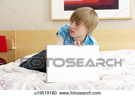 Guilty Teenage Boy Using Laptop In Bedroom View Large Photo Image Stock Image - Guilty Teenage Boy Using Laptop In Bedroom. Fotosearch