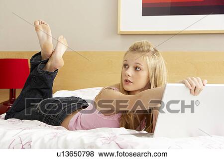 Guilty Teenage Girl Using Laptop In Bedroom View Large Photo Image Stock Photo - Guilty Teenage Girl Using Laptop In Bedroom. Fotosearch
