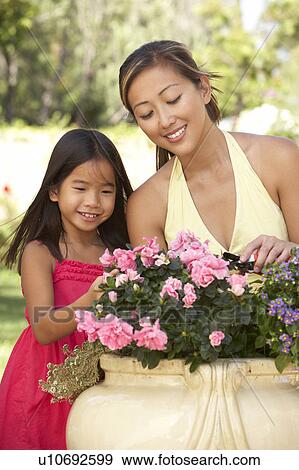 Stock Photo - Mother And Daughter Gardening Together. Fotosearch