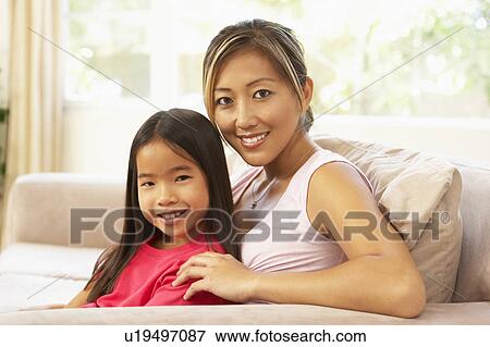 Mother And Daughter Relaxing On Sofa At Home View Large Photo Image Stock Photo - Mother And Daughter Relaxing On Sofa At Home. Fotosearch