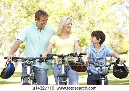 Stock Photograph - Parents And Son On Cycle Ride In Park. Fotosearch