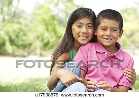 Stock Photo - Portrait Of Brother And Sister In Park. Fotosearch