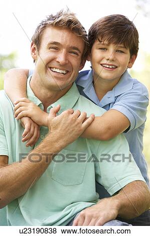 Stock Photo - Portrait Of Father And Son In Park. Fotosearch