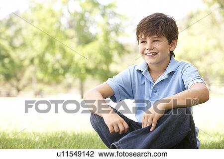 Portrait Of Young Boy Sitting In Park View Large Photo Image Stock Image - Portrait Of Young Boy Sitting In Park. Fotosearch