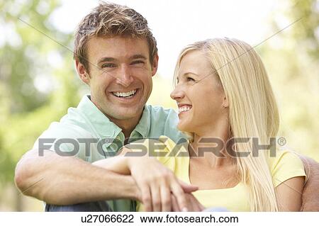 Portrait Of Young Couple Sitting In Park View Large Photo Image Stock Image - Portrait Of Young Couple Sitting In Park. Fotosearch