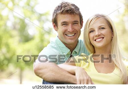 Portrait Of Young Couple Sitting In Park View Large Photo Image Stock Photography - Portrait Of Young Couple Sitting In Park. Fotosearch