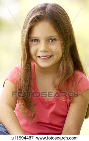 Stock Photo - Portrait Of Young Girl Sitting In Park. Fotosearch