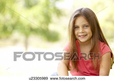 Stock Photo - Portrait Of Young Girl Sitting In Park. Fotosearch