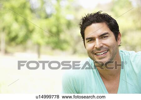 Stock Photo - Portrait Of Young Man In Park. Fotosearch