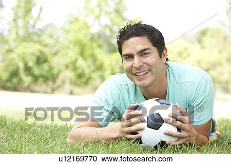 Stock Image - Portrait Of Young Man In Park With Football. Fotosearch