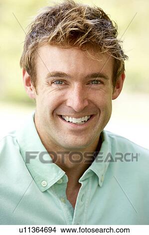 Picture - Portrait Of Young Man Sitting In Park. Fotosearch