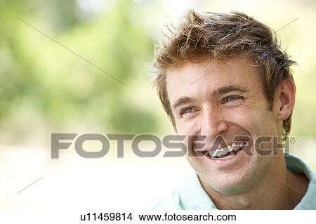 Picture - Portrait Of Young Man Sitting In Park. Fotosearch