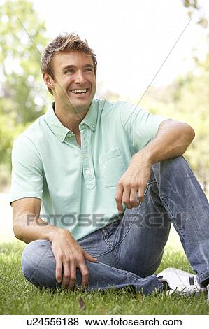 Portrait Of Young Man Sitting In Park View Large Photo Image Stock Photo - Portrait Of Young Man Sitting In Park. Fotosearch