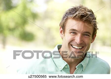 Stock Photography - Portrait Of Young Man Sitting In Park. Fotosearch