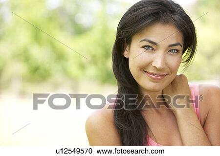 Stock Image - Portrait Of Young Woman In Park. Fotosearch