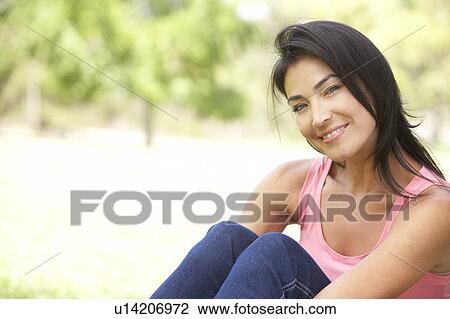 Stock Image - Portrait Of Young Woman In Park. Fotosearch