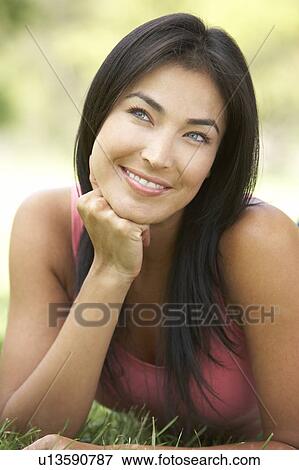 Stock Photo - Portrait Of Young Woman In Park. Fotosearch