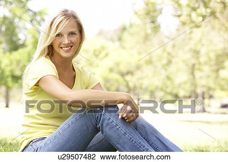 Portrait Of Young Woman Sitting In Park View Large Photo Image Stock Image - Portrait Of Young Woman Sitting In Park. Fotosearch