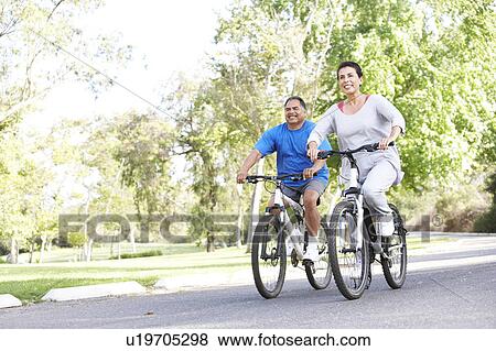 Senior Couple Cycling In Park View Large Photo Image Stock Photo - Senior Couple Cycling In Park. Fotosearch