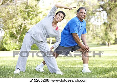 Stock Photograph - Senior Couple Exercising In Park. Fotosearch