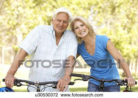 Senior Couple On Cycle Ride In Park View Large Photo Image Stock Image - Senior Couple On Cycle Ride In Park. Fotosearch