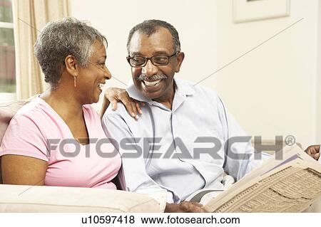 Stock Photo - Senior Couple Reading Newspaper At Home. Fotosearch