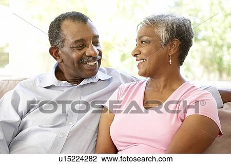 Stock Image - Senior Couple Relaxing At Home Together. Fotosearch