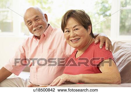 Stock Image - Senior Couple Relaxing At Home Together. Fotosearch