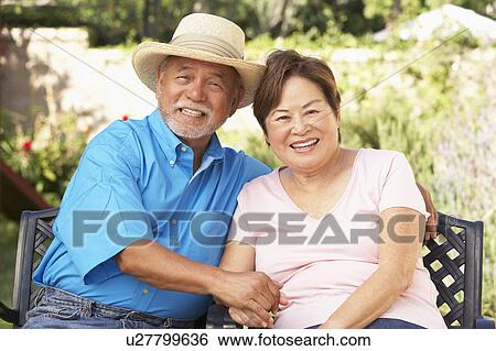 Stock Photograph - Senior Couple Relaxing In Garden Together. Fotosearch