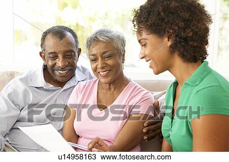 Stock Image - Senior Couple Talking To Financial Advisor At Home. Fotosearch