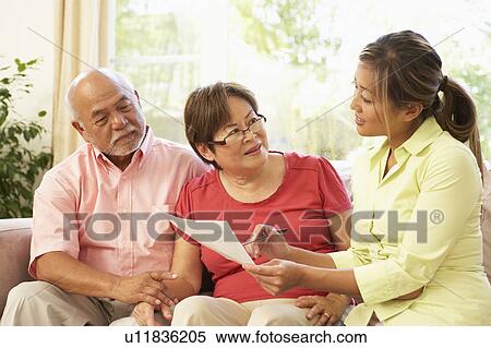 Stock Photography - Senior Couple Talking To Financial Advisor At Home. Fotosearch