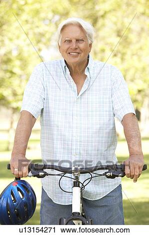 Stock Image - Senior Man On Cycle Ride In Park. Fotosearch