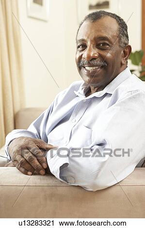 Stock Image - Senior Man Relaxing In Chair At Home. Fotosearch