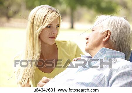 Stock Image - Senior Man Talking To Concerned Adult Daughter. Fotosearch