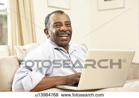 Stock Photo - Senior Man Using Laptop At Home. Fotosearch