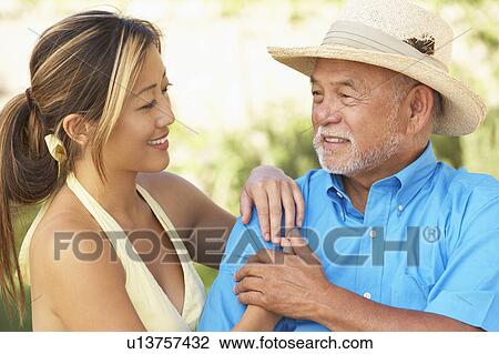 Stock Image - Senior Man With Adult Daughter In Garden. Fotosearch