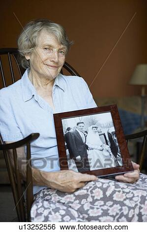 Senior Woman At Home Looking At Old Wedding Photo View Large Photo Image Stock Photograph - Senior Woman At Home Looking At Old Wedding Photo. Fotosearch