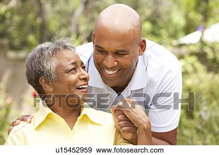 Senior Woman Being Hugged By Adult Son View Large Photo Image Stock Photo - Senior Woman Being Hugged By Adult Son. Fotosearch